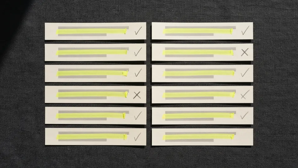 Strips of a printed answer laid out in two columns, each marked in yellow and ticked or crossed in pencil