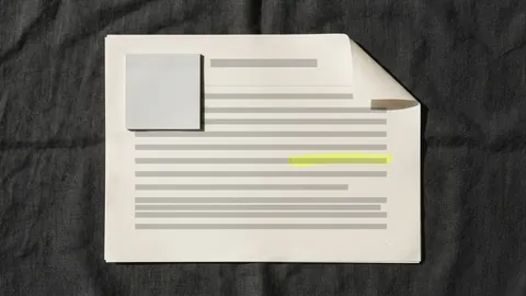 A printed report page with one yellow line, a pale grey sticky note and a curled top corner