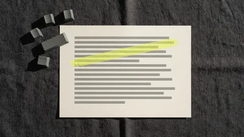 Loose blank keyboard keycaps next to a printed page with one line marked in yellow