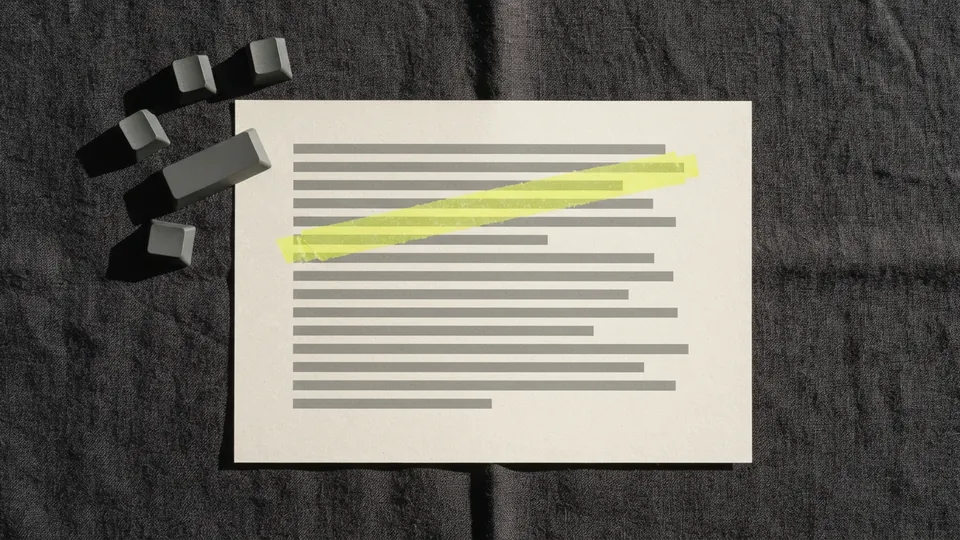 Loose blank keyboard keycaps next to a printed page with one line marked in yellow