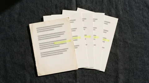 A fanned stack of printed pages with the same line marked in yellow on each, the front sheet older and yellowed