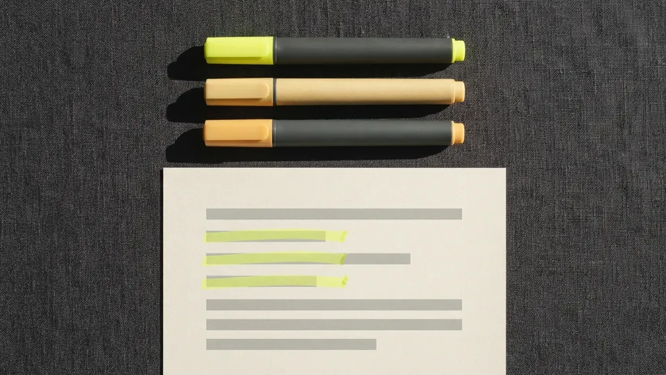 Three highlighters in yellow, pale ochre and amber above a page with three short strokes